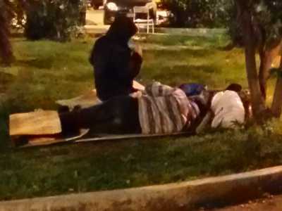 Un clochard dorme nei giardinetti di Piazza Moro nei pressi della stazione ferroviaria